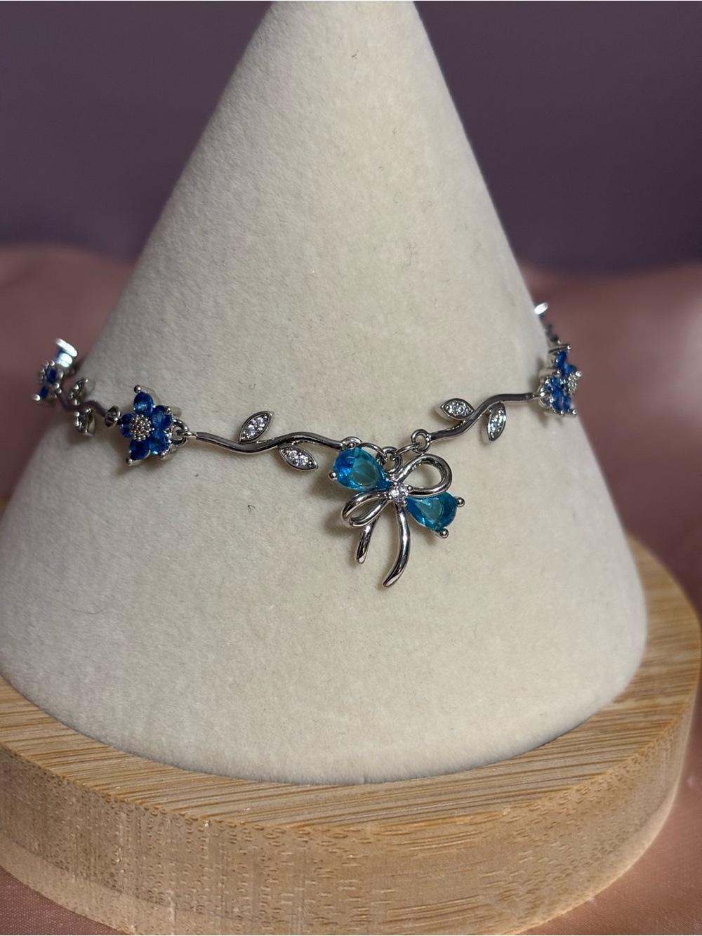 Silver Floral Bow Bracelet with Blue Gem Accents